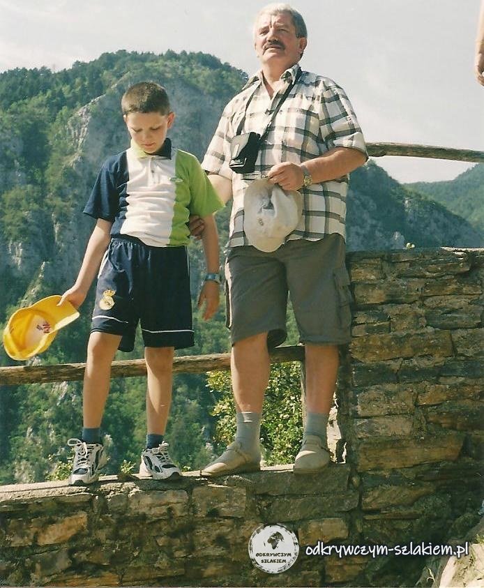 Z tatą na kamiennym murku, w tle zalesione zbocza Olimpu