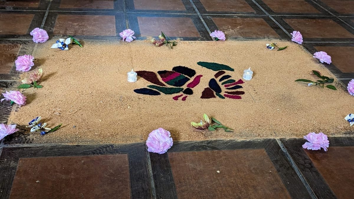 Dywan ułożony z kolorowych trocin i kwiatów na posadzce w Antigua Guatemala