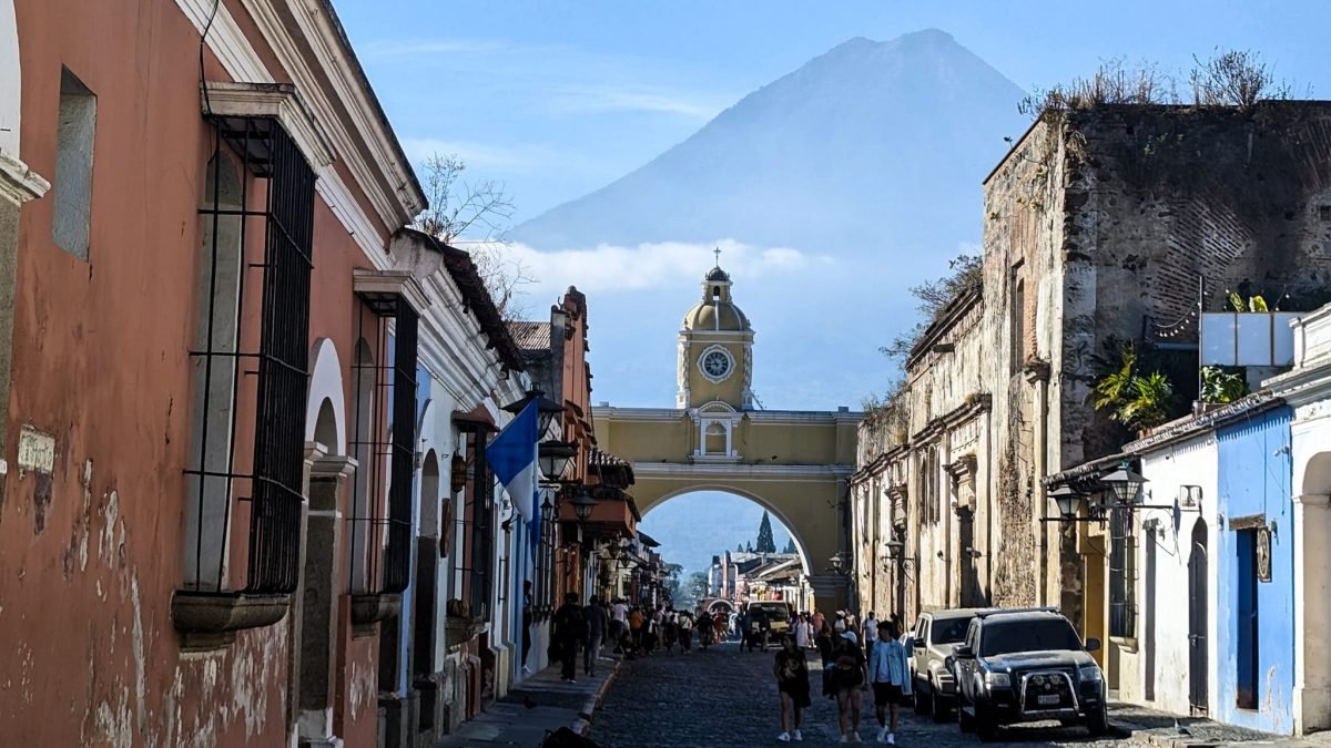 Ulica w Antigua Guatemala z łukiem Arco de Santa Catalina, a w tle stożek wulkanu Agua