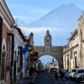 Ulica w Antigua Guatemala z łukiem Arco de Santa Catalina, a w tle stożek wulkanu Agua