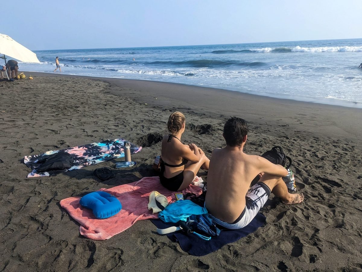 Czarny wulkaniczny piasek i fale Pacyfiku na plaży w El Paredón