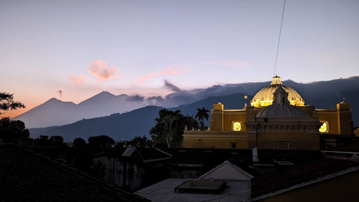 Zachód słońca nad wulkanami i kopułą kościoła w Antigua Guatemala