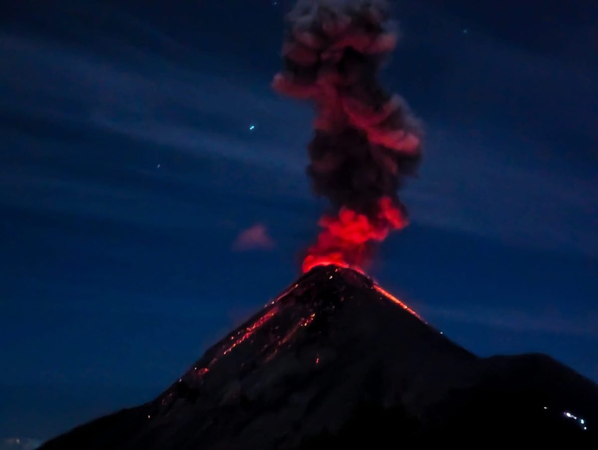 Czerwona od lawy chmura nad Fuego podczas nocnej erupcji