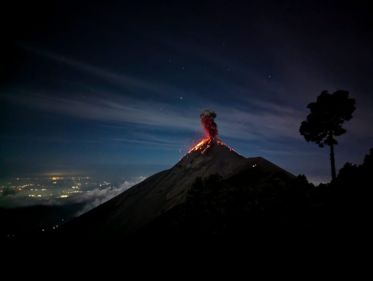 Erupcja Fuego nocą, w dole światła miejscowości w dolinie
