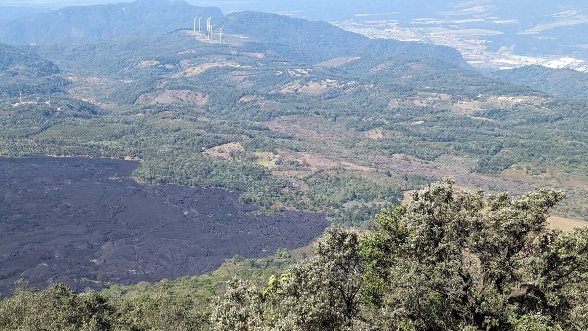 Czarne pole zastygłej lawy z erupcji Pacayi w 2014 roku wśród zielonych wzgórz