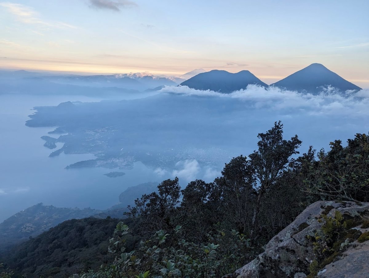 Widok z wulkanu San Pedro na jezioro Atitlán i wulkany Tolimán i Atitlán ponad chmurami