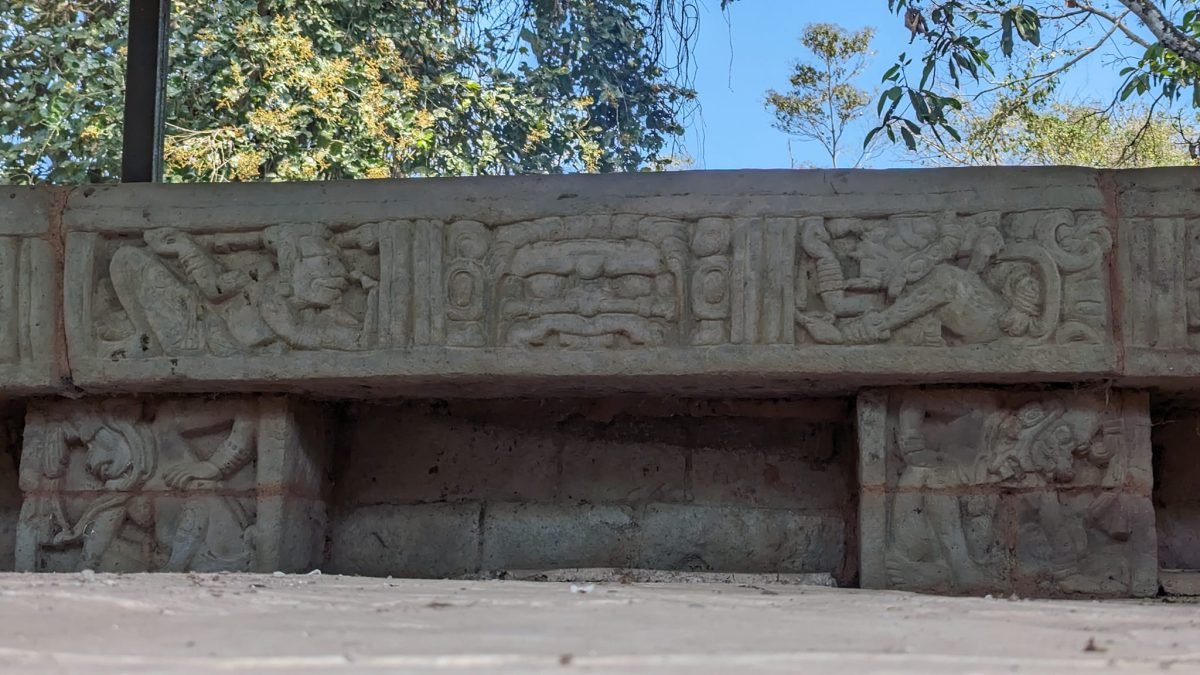 Kamienna ława z płaskorzeźbionymi postaciami w ruinach Copán