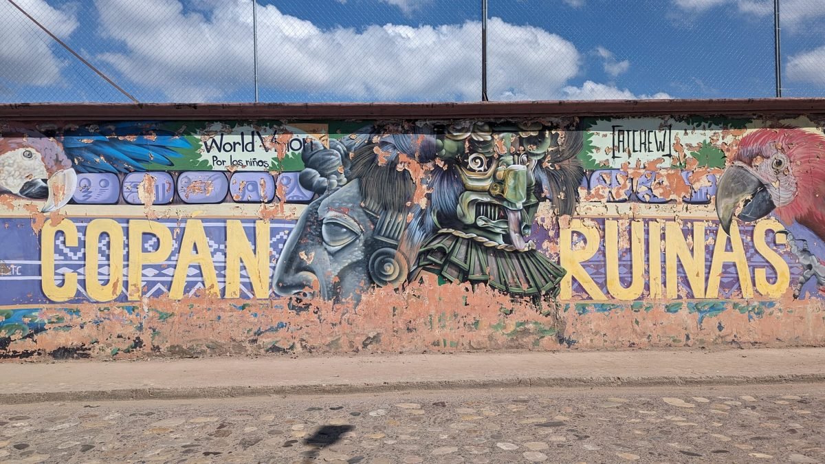 Kolorowy mural z napisem Copán Ruinas i papugami ara na murze w miasteczku