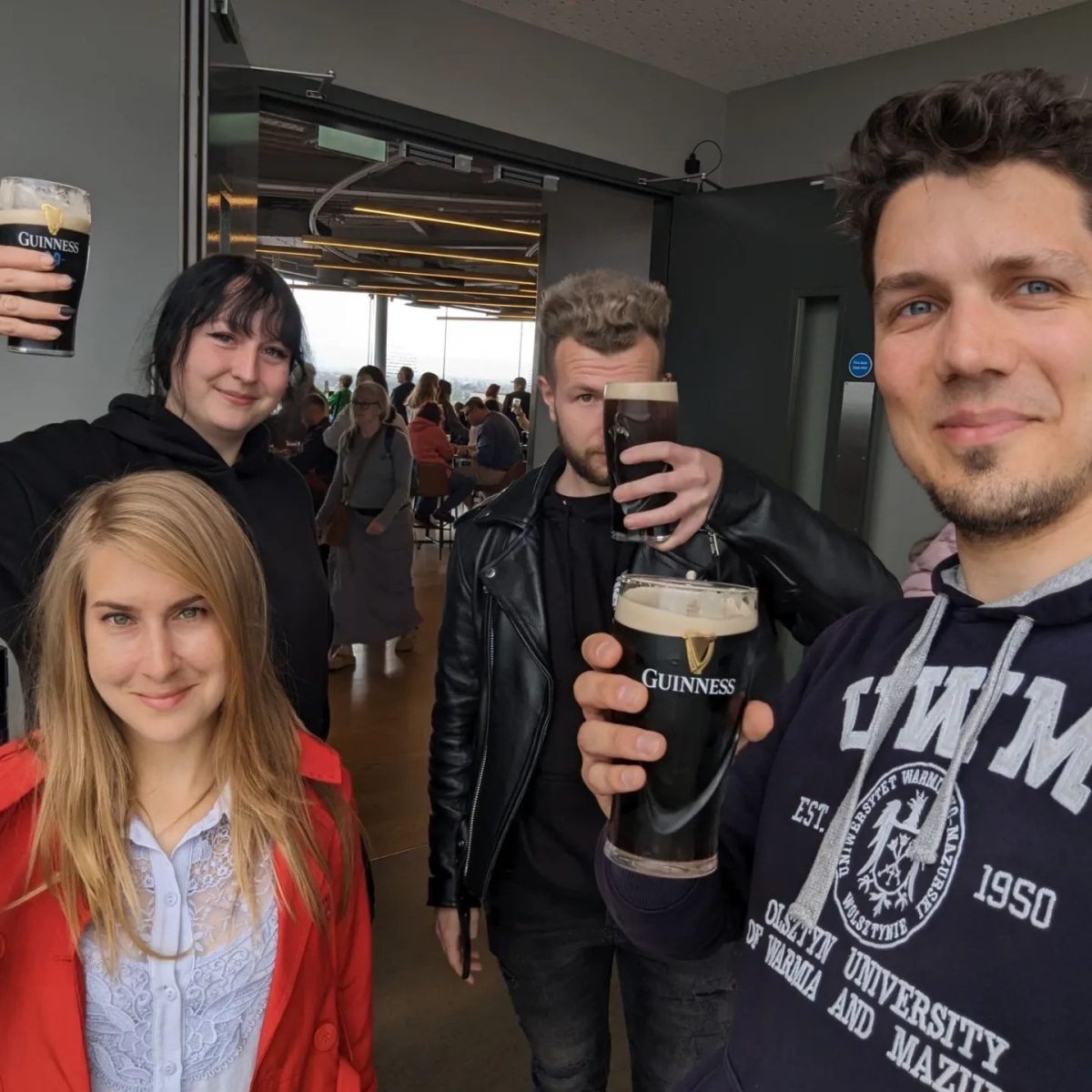 We czwórkę z Robertem i Asią z pintami Guinnessa w barze na szczycie Guinness Storehouse w Dublinie
