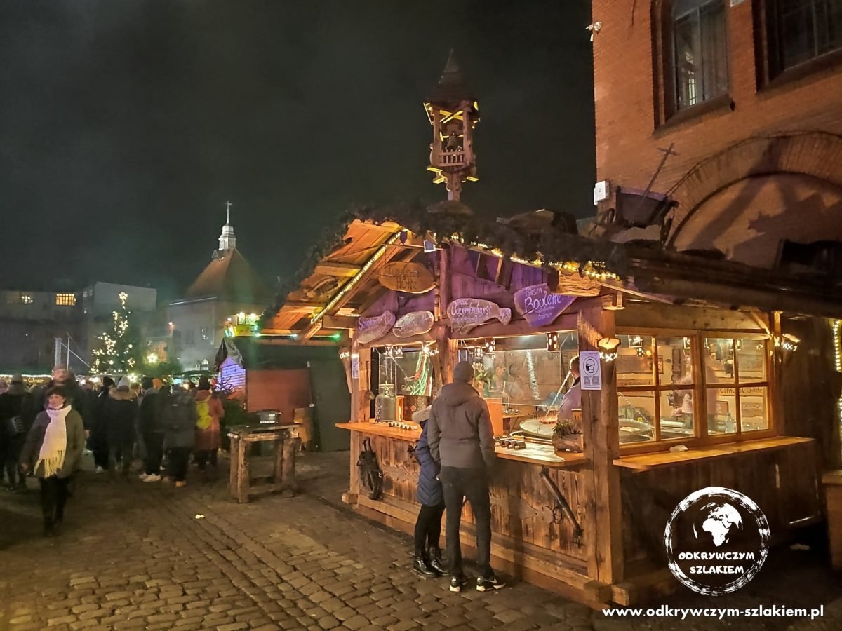 Drewniana budka z jedzeniem przy ceglanym budynku Kulturbrauerei w Berlinie