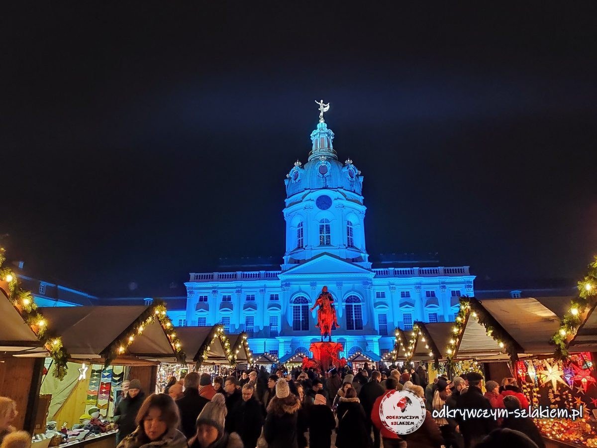 Podświetlony Pałac Charlottenburg nad jarmarkiem świątecznym