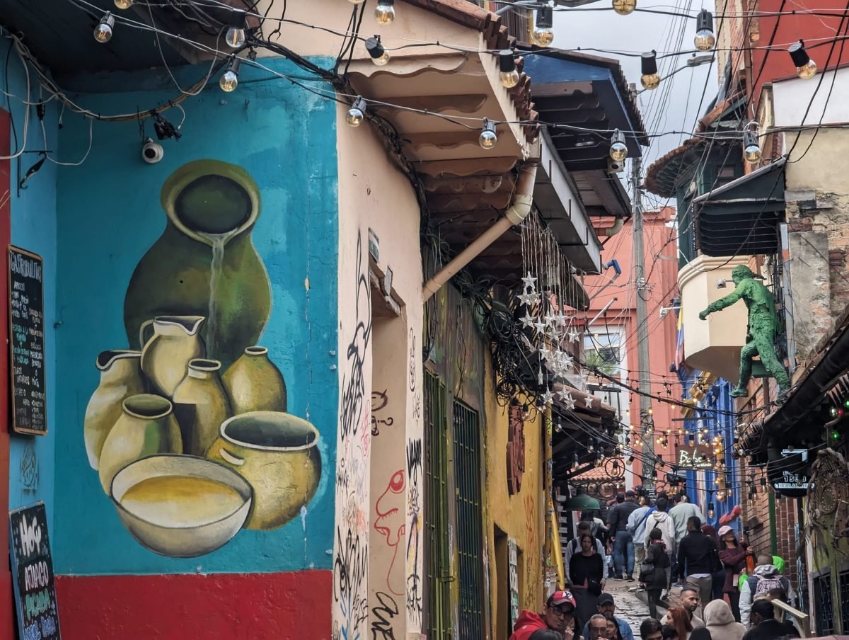 Mural z glinianymi dzbanami na uliczce przy Chorro de Quevedo w Bogocie, w głębi tłum spacerowiczów