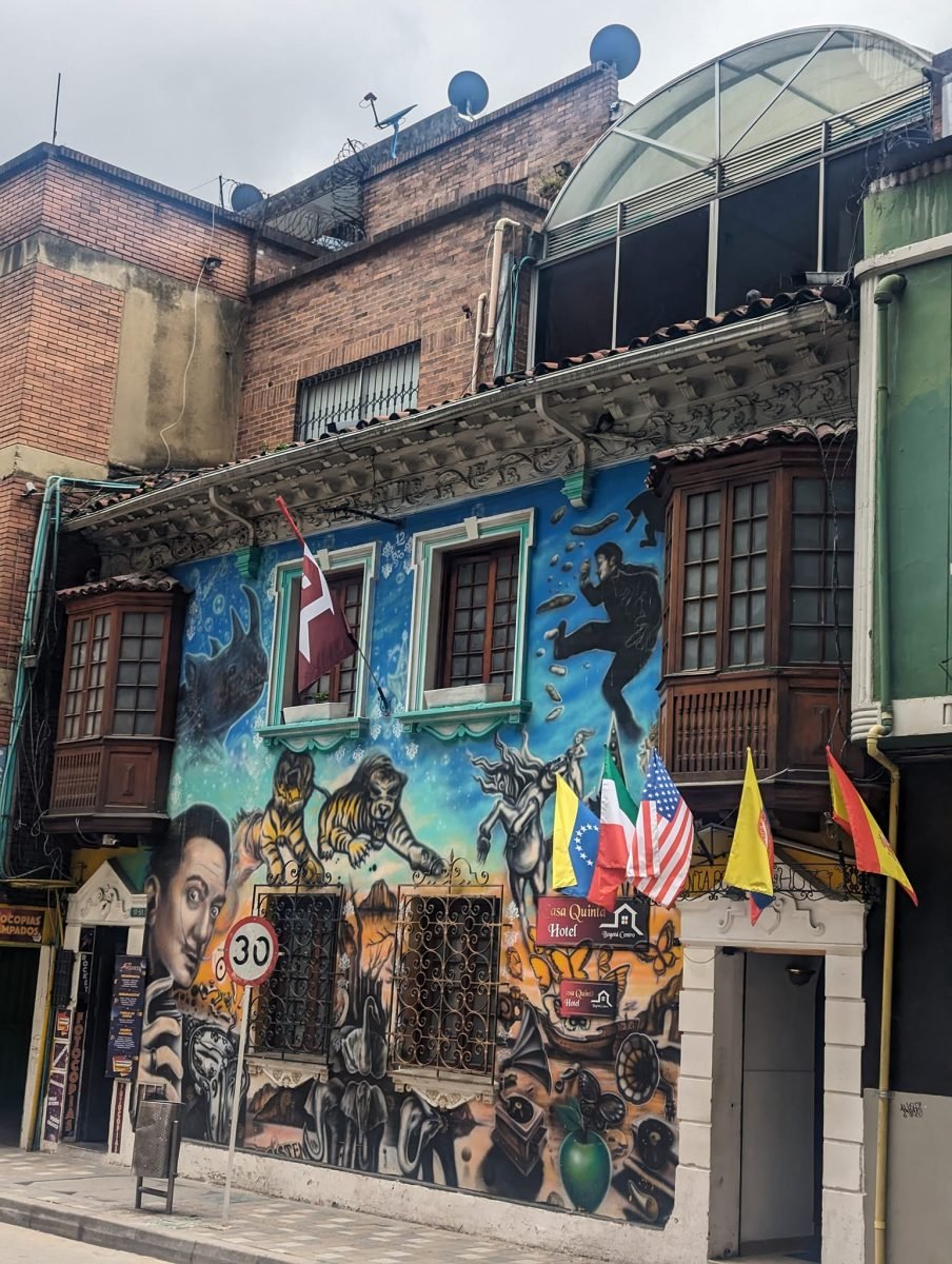 Kolorowy mural na fasadzie starej kamienicy z drewnianymi balkonami w centrum Bogoty