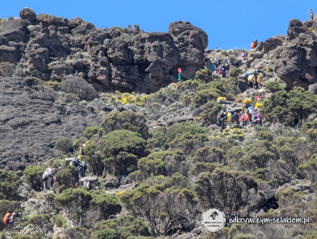 Sznur turystów i tragarzy na zboczu Barranco Wall