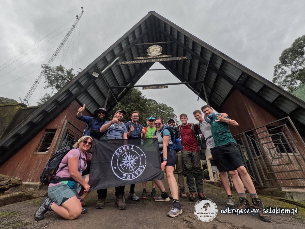 Nasza ekipa z flagą pod bramą Machame Gate w Parku Narodowym Kilimandżaro