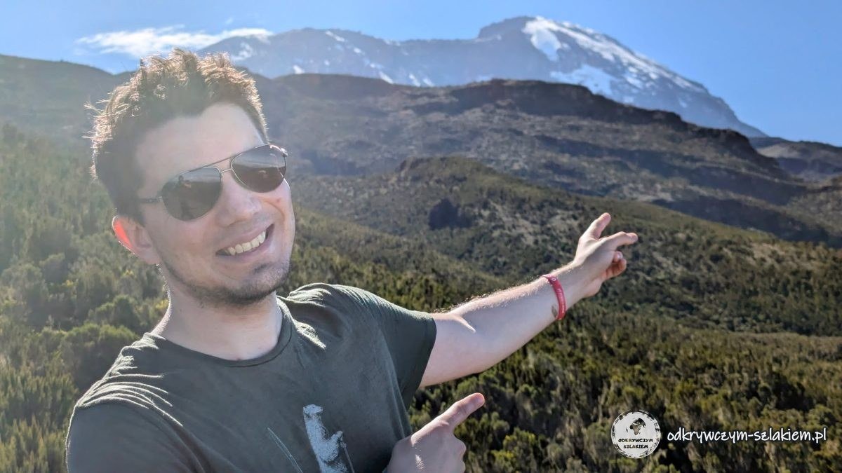 Maciek wskazuje ośnieżony szczyt Kibo na Kilimandżaro z wrzosowisk powyżej Machame Camp