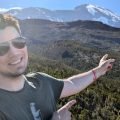 Maciek wskazuje ośnieżony szczyt Kibo na Kilimandżaro z wrzosowisk powyżej Machame Camp