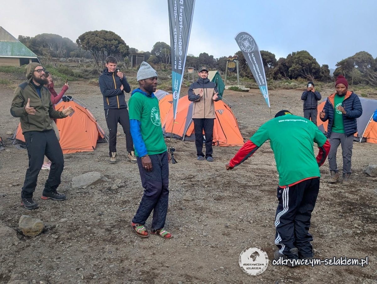 Tańce powitalne ekipy agencji między namiotami w Shira Cave Camp