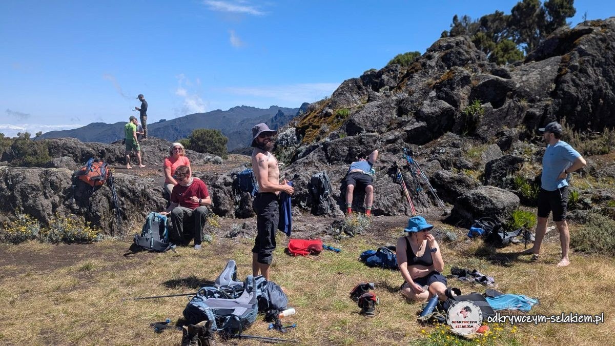 Przerwa na kawę i ciastka na trawie w słońcu w drodze do Shira Cave Camp