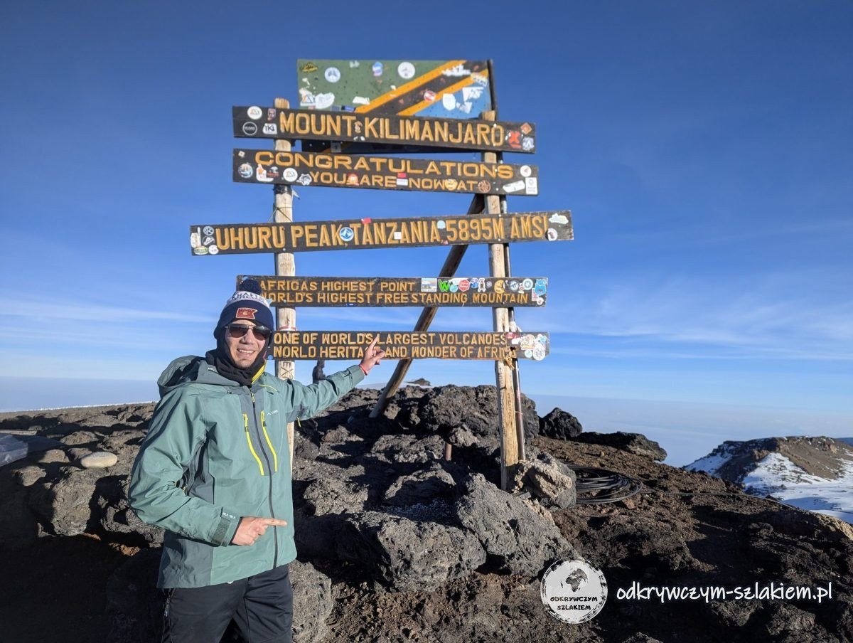 Maciek pod tablicą Uhuru Peak (5895 m n.p.m.) na szczycie Kilimandżaro