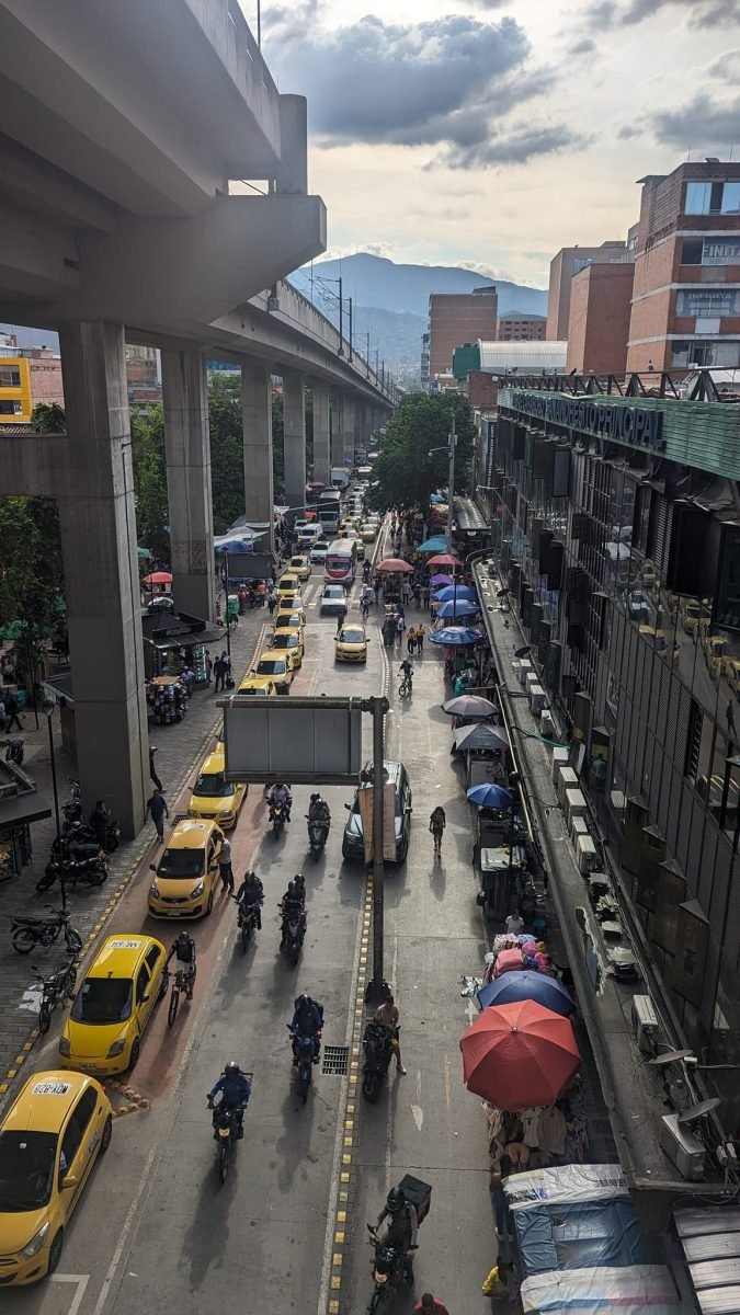 Ulica w centrum Medellín pod estakadą metra, z żółtymi taksówkami