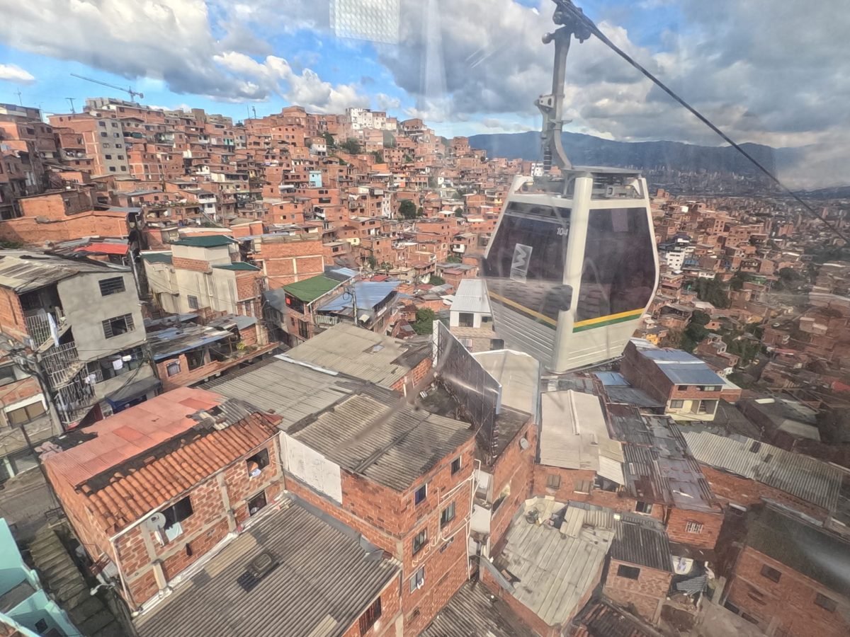 Wagonik kolejki Metrocable nad ceglanymi domami na zboczu w Medellín
