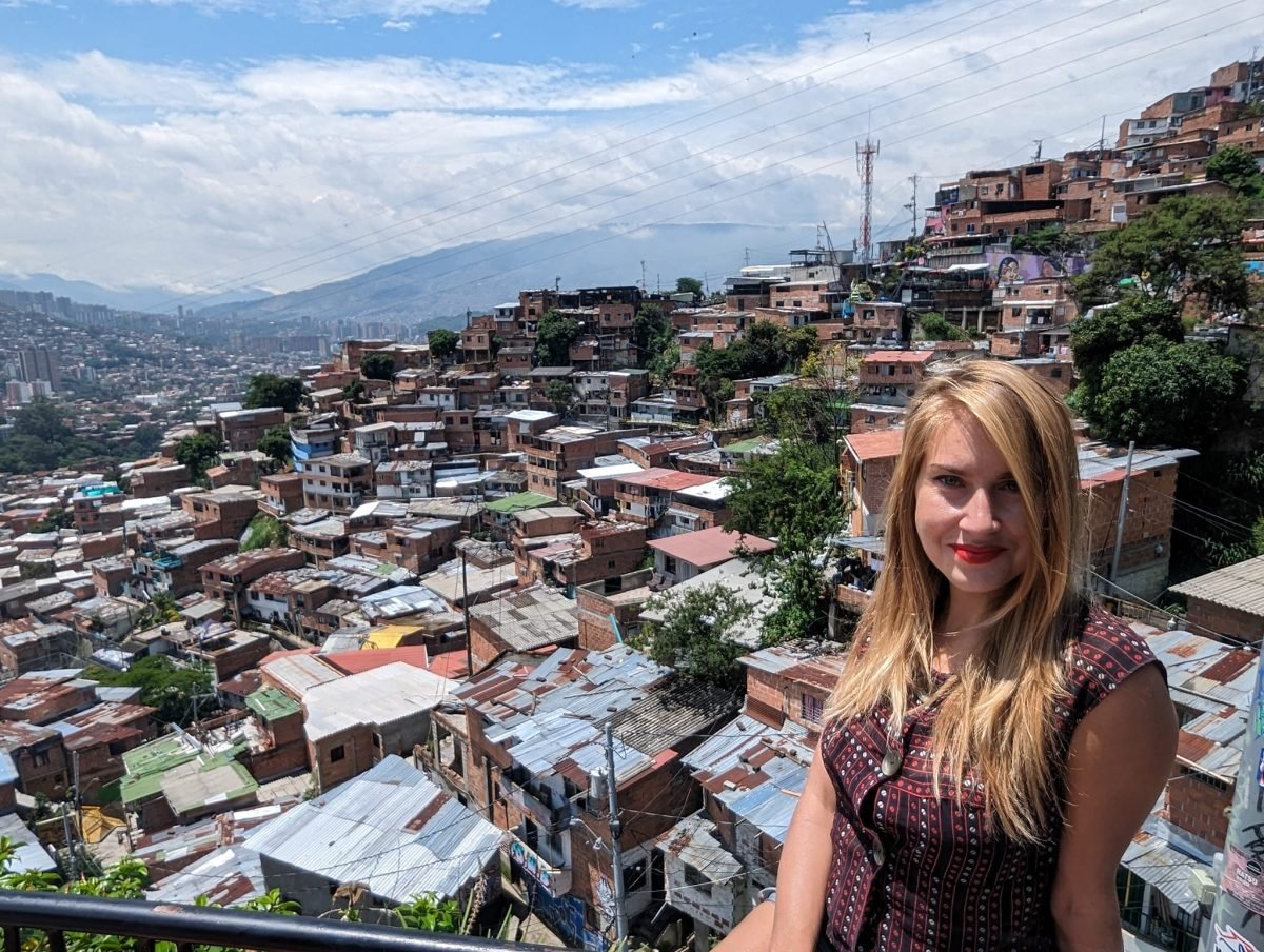 Patrycja na tle ceglanych domów Comuna 13 i doliny Medellín