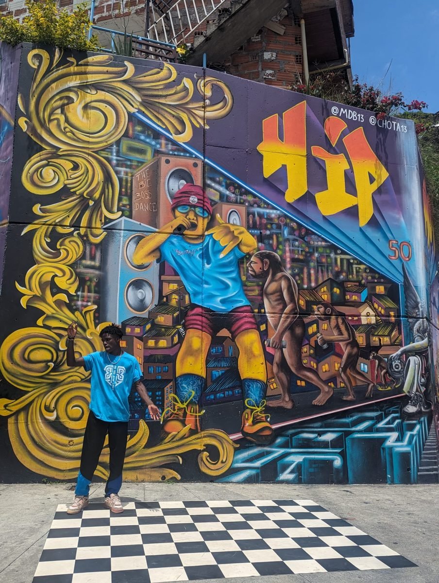 Tancerz breakdance’u przed muralem Hip Hop 50 w Comuna 13