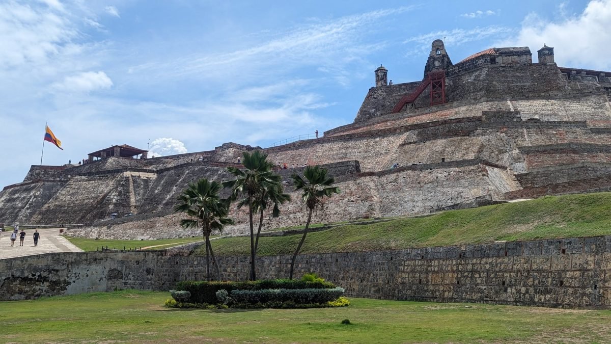 Masywne mury fortu Castillo San Felipe de Barajas w Kartagenie z kolumbijską flagą na szczycie