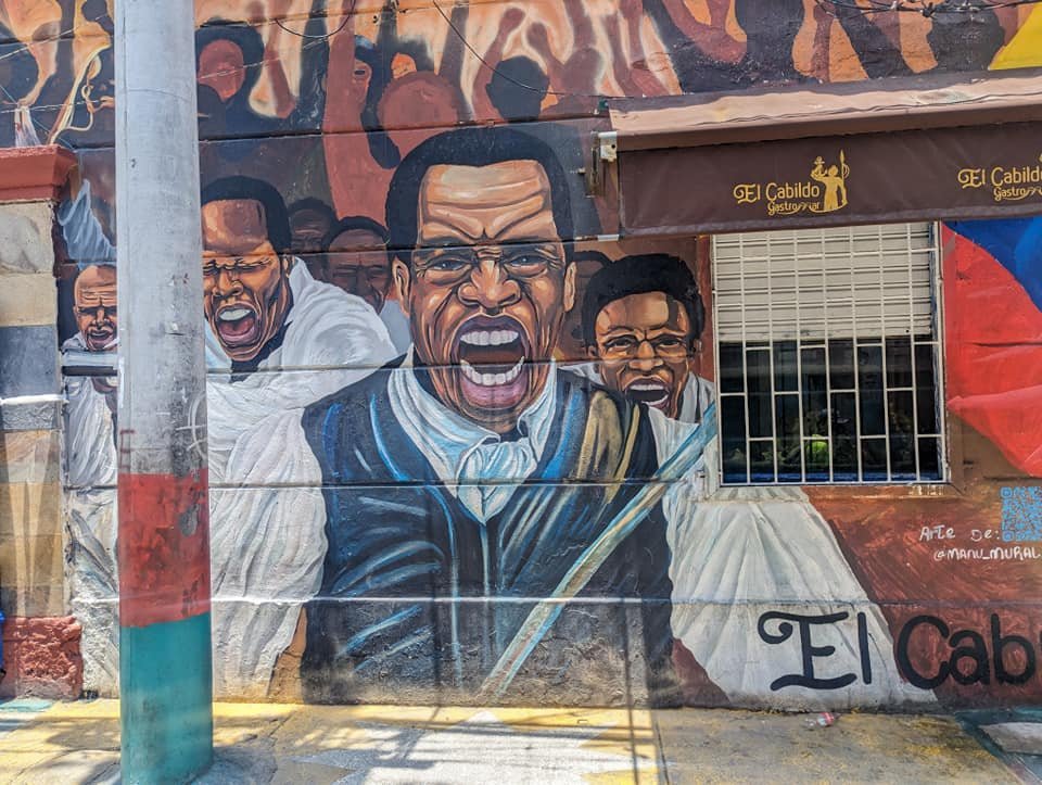 Mural z portretami mieszkańców na ścianie budynku w Getsemaní