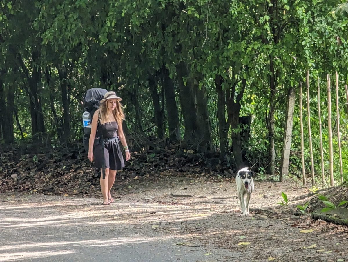Patrycja z plecakiem na piaszczystej drodze w okolicy parku Tayrona, obok pies