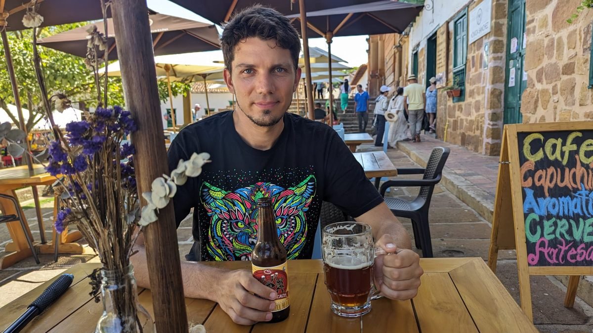 Maciek z piwem rzemieślniczym przy stoliku kawiarni na uliczce w Baricharze