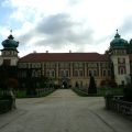 Avenue with yews clipped into cones leading to the gate of Łańcut Castle, with two towers topped by green cupolas
