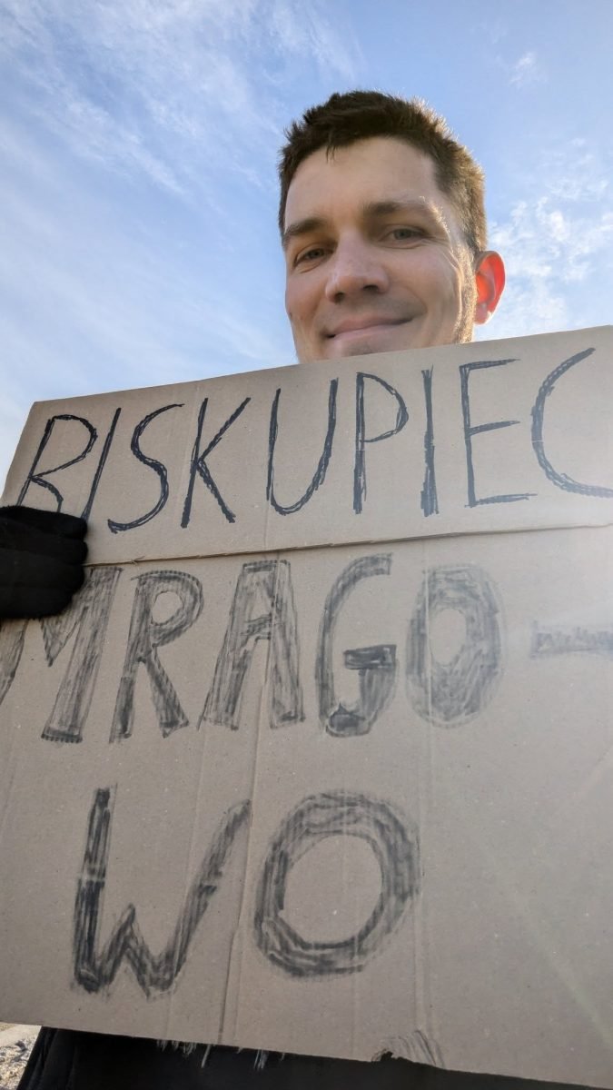 Kartonowa tabliczka z napisem „Biskupiec, Mrągowo” przy łapaniu stopa w Olsztynie