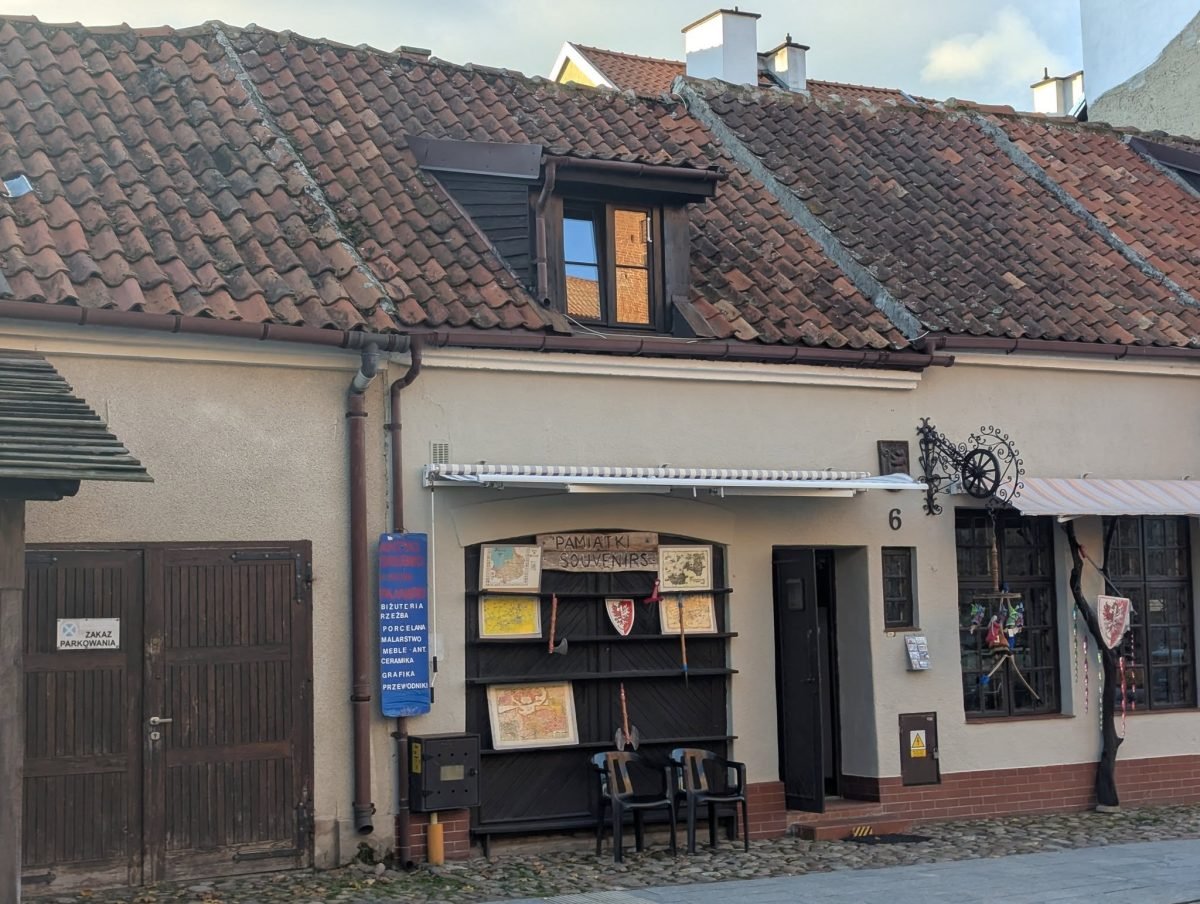 Stara kamienica z drewnianą witryną przy uliczce w Reszlu
