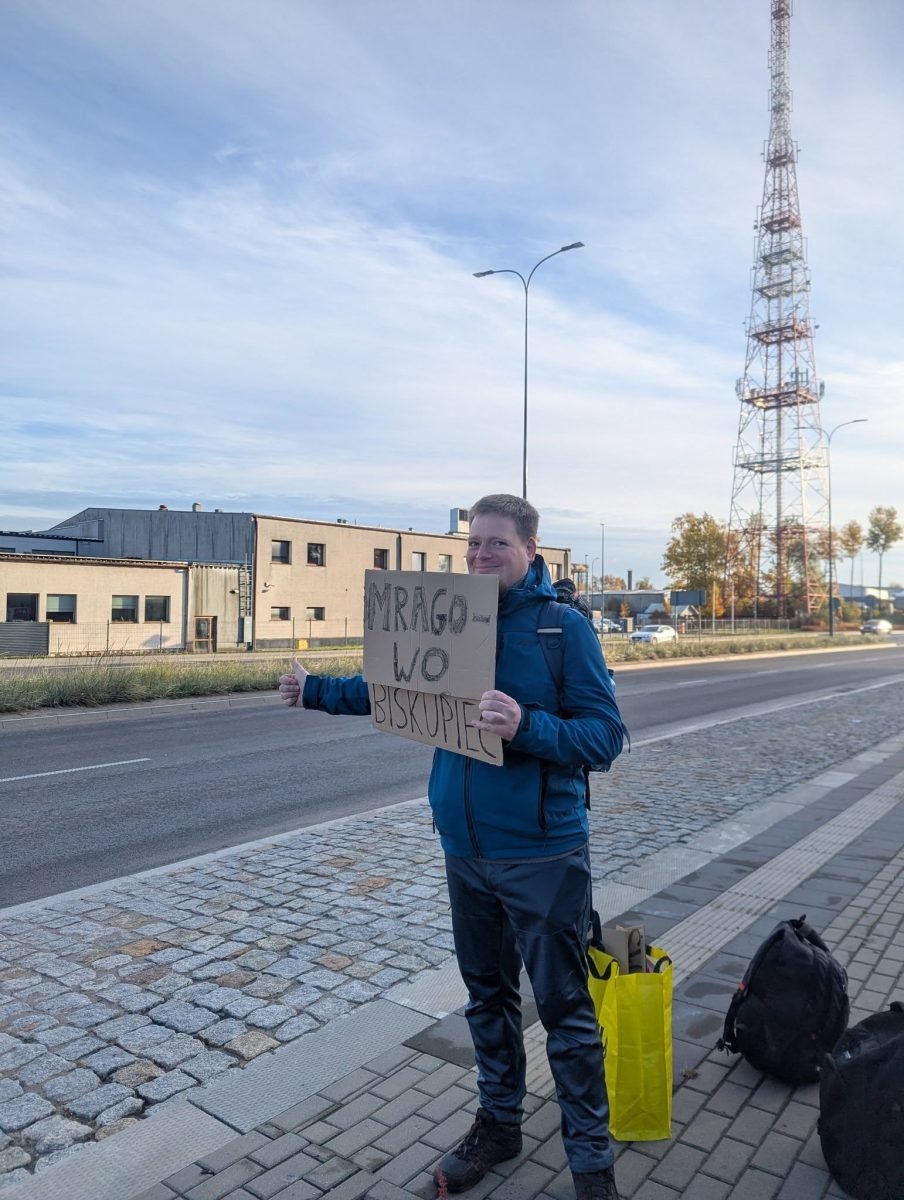 Łapanie stopa z tabliczką „Mrągowo” przy wylotówce na ulicy Towarowej w Olsztynie