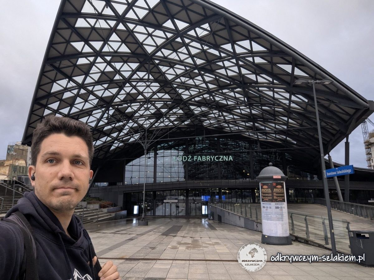 Maciek przed wejściem na dworzec Łódź Fabryczna pod kratownicowym dachem