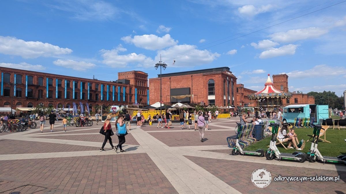 Rynek Manufaktury w Łodzi latem otoczony budynkami z czerwonej cegły