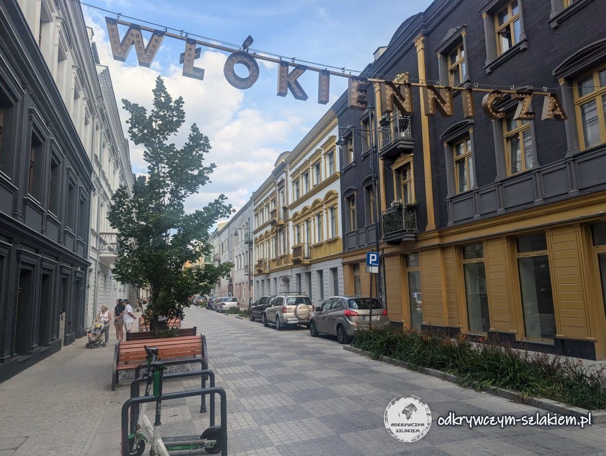 Odnowiona ulica Włókiennicza w Łodzi z napisem nad ulicą, ławkami i zielenią