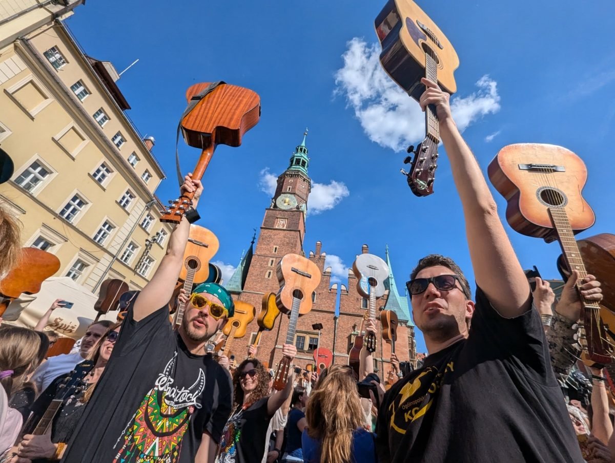 Uczestnicy Gitarowego Rekordu Guinnessa unoszą gitary na wrocławskim Rynku przed ratuszem