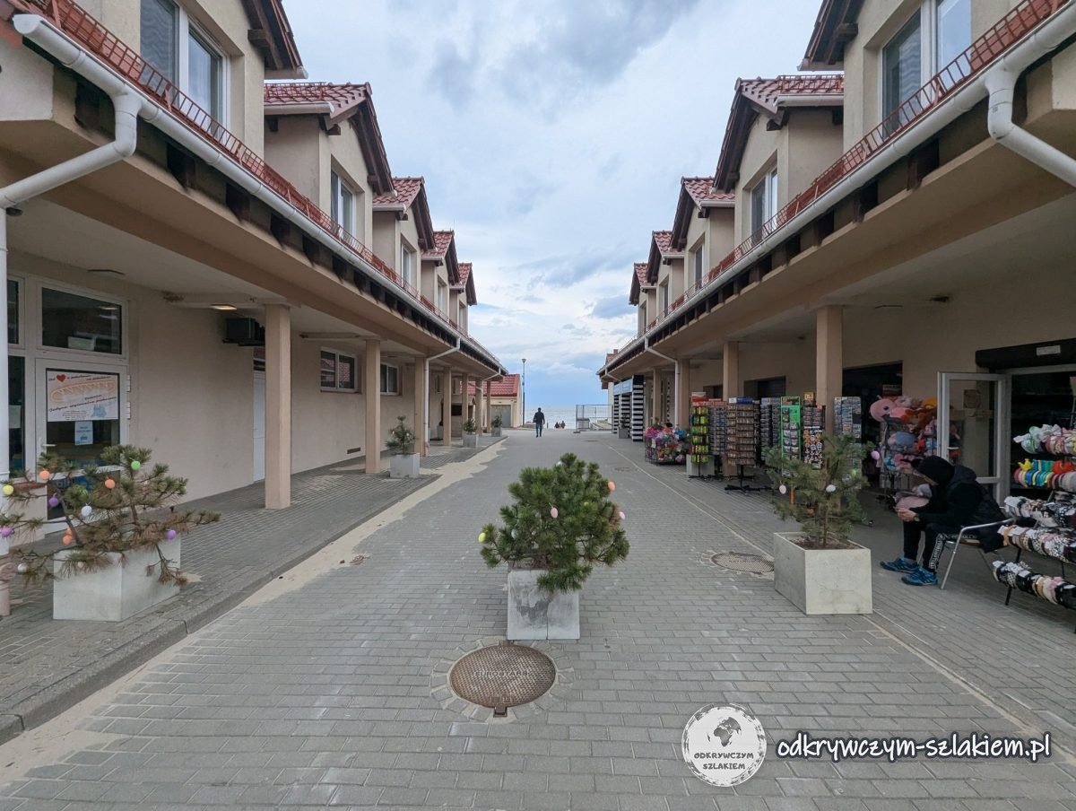 Paseo con puestos de recuerdos en Krynica Morska, pinos pequeños en macetas adornados con huevos de Pascua