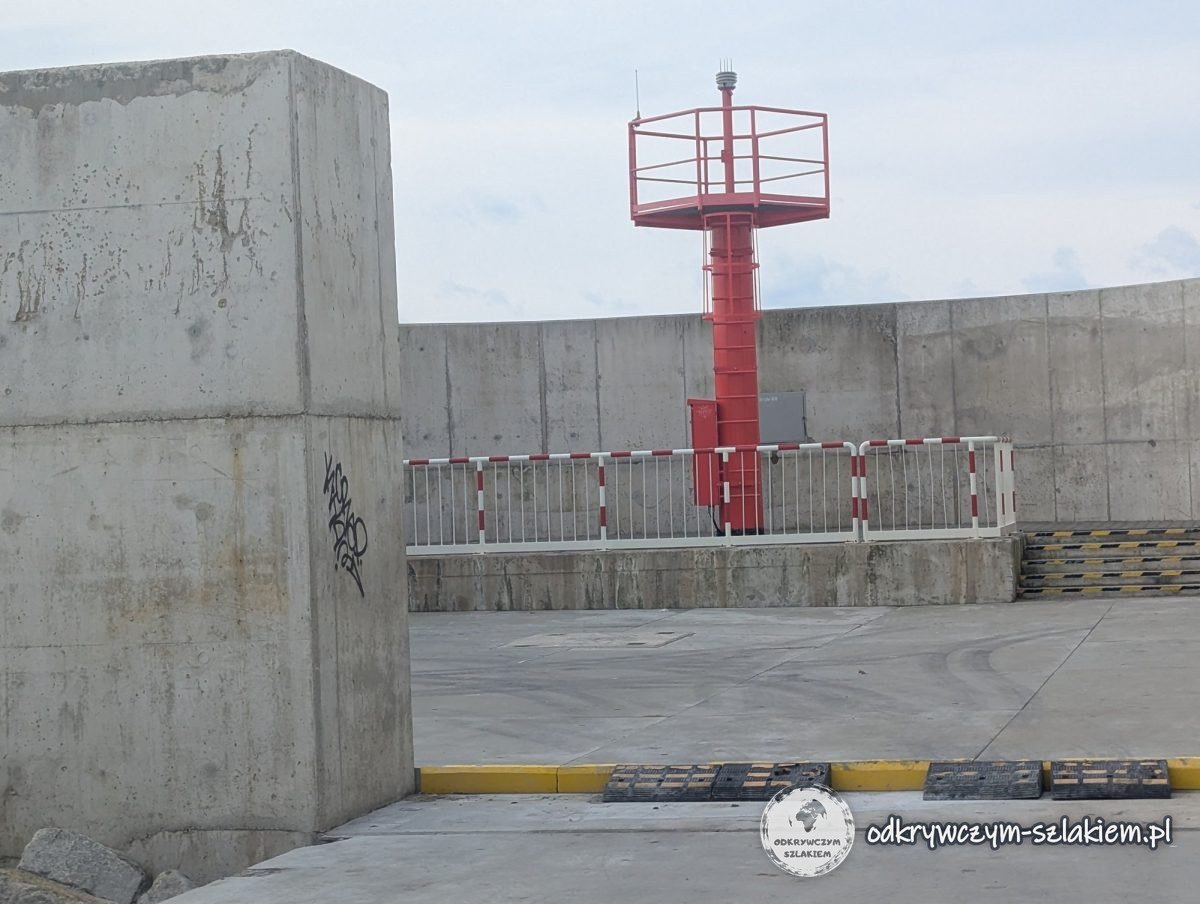 Torre roja con luz de navegación al final del rompeolas de hormigón del canal de la Lengua del Vístula