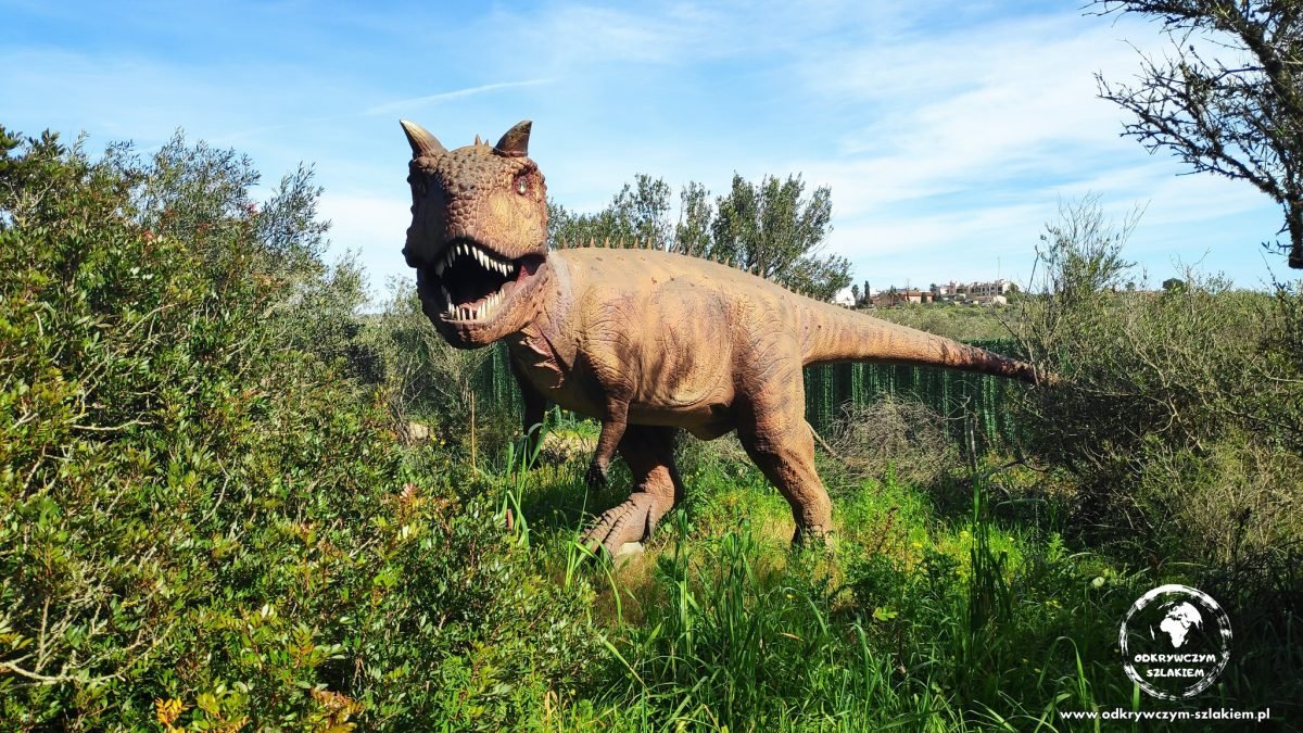 Model drapieżnego dinozaura wśród zieleni w parku Dinosaurland