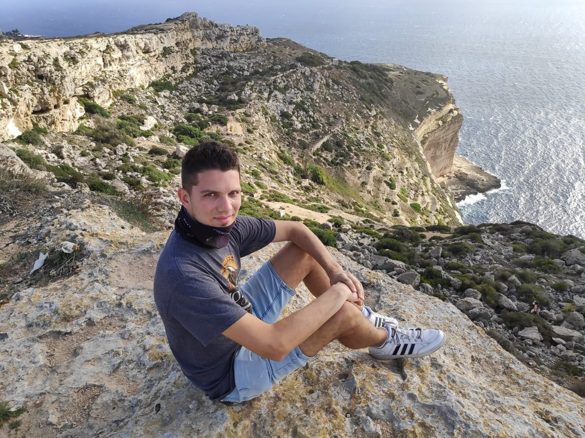 Maciek na krawędzi klifów Dingli, w tle urwiska opadające do morza