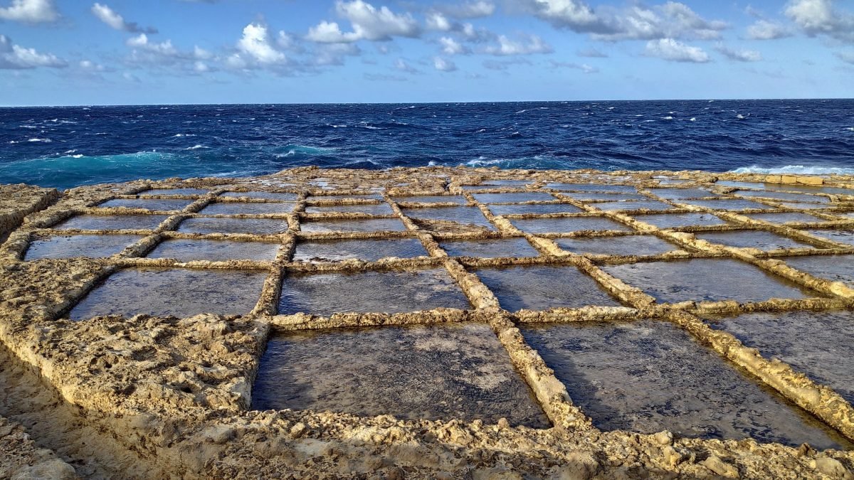 Prostokątne solniska wykute w skale nad morzem przy zatoce Xwejni na Gozo