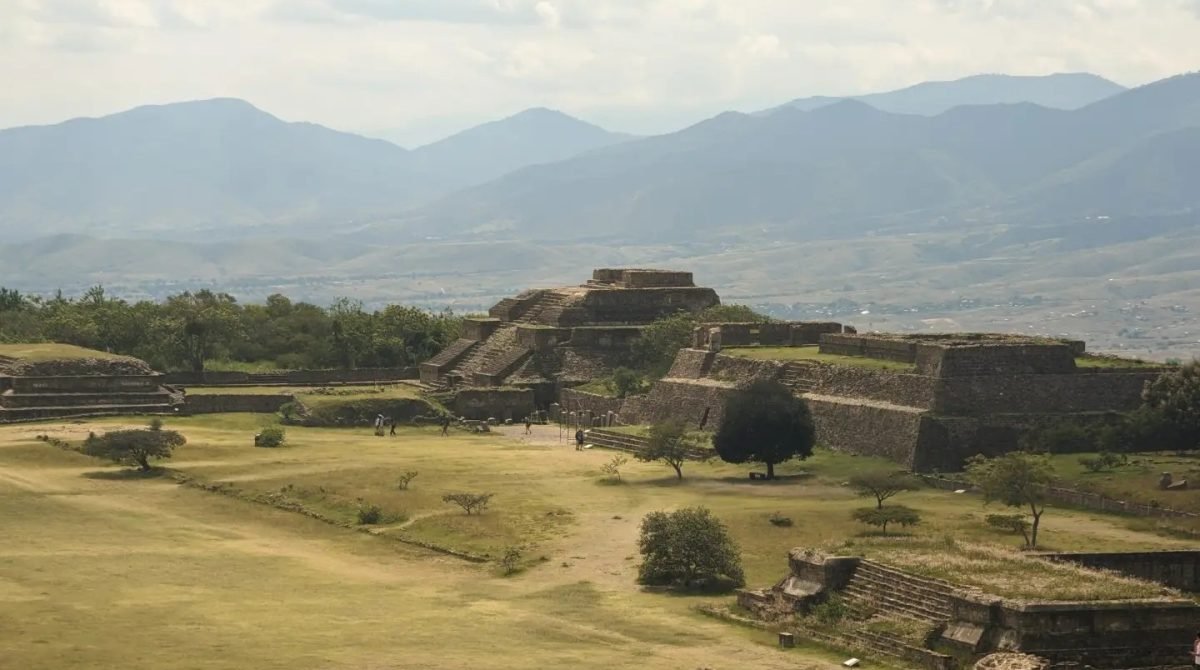 Ruiny Monte Albán na rozległym placu, w tle pasma gór