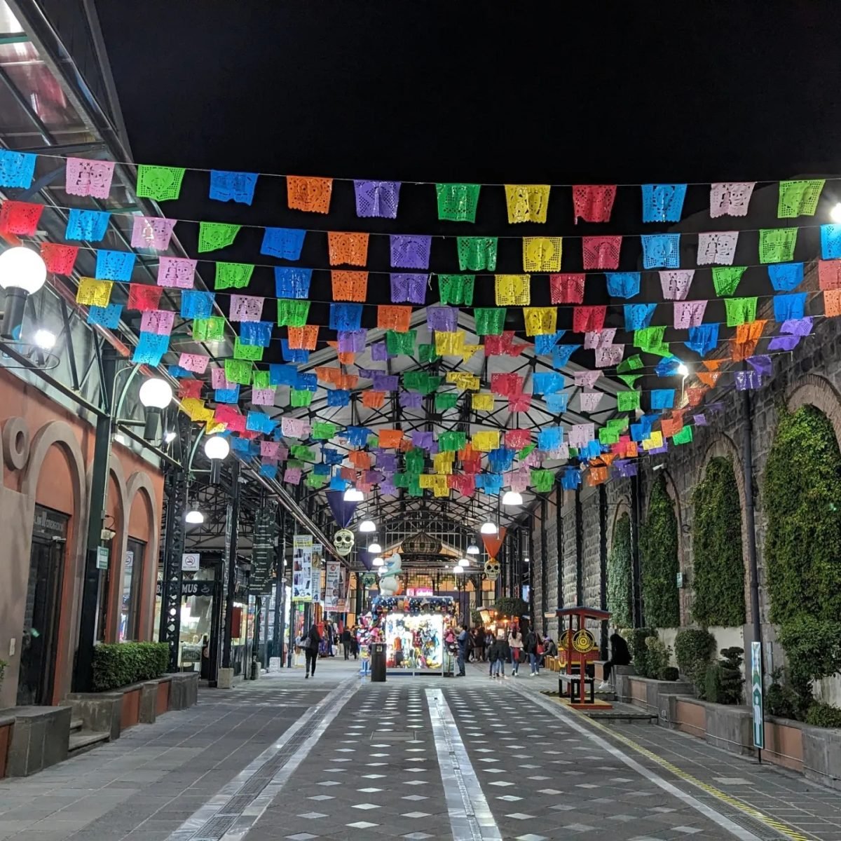 Kolorowe papel picado rozwieszone nad deptakiem w Puebli nocą
