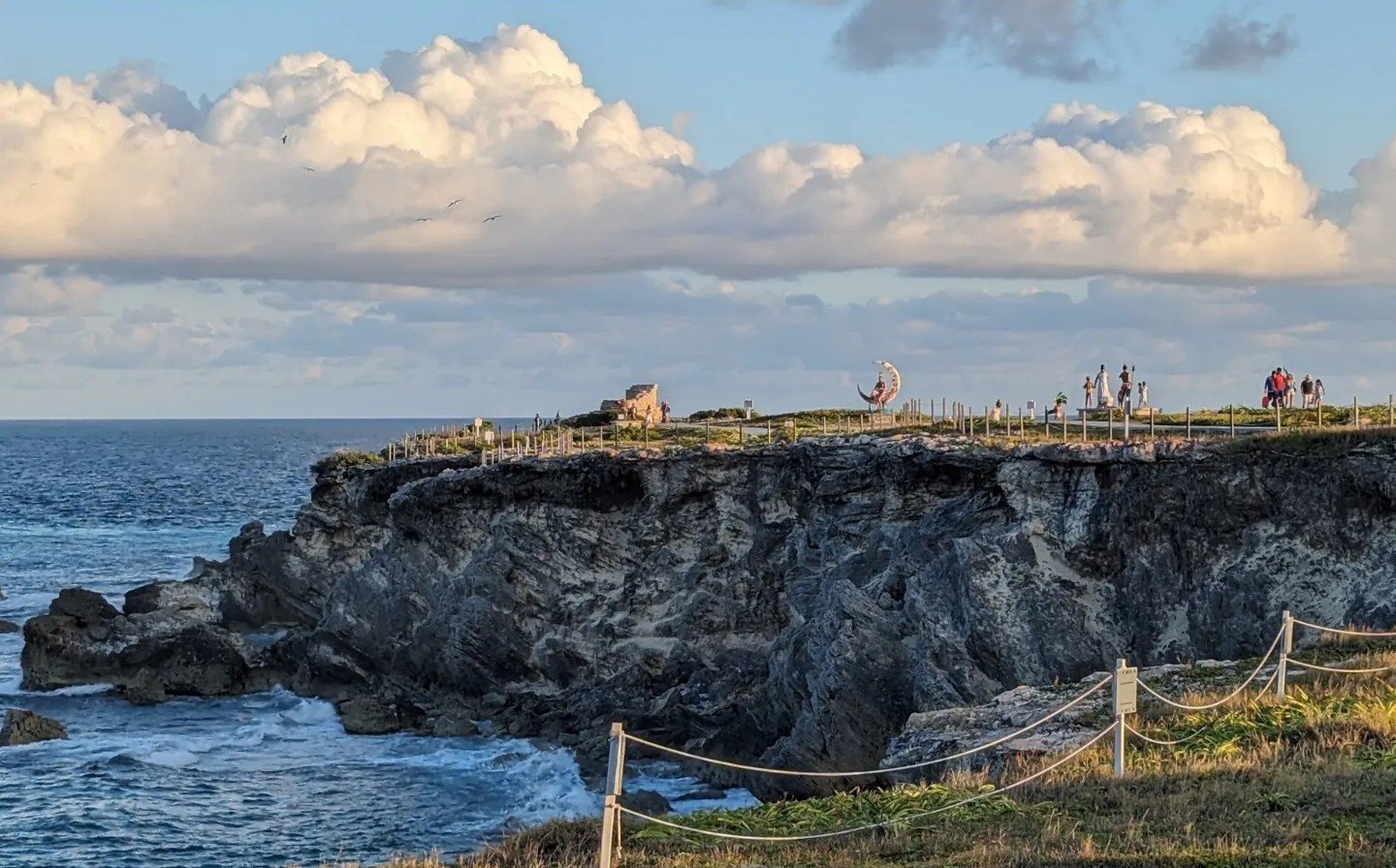 Skaliste klify Punta Sur na południowym krańcu Isla Mujeres, na szczycie rzeźby i turyści