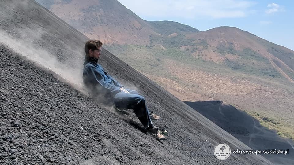 Zjazd na desce po stromym, czarnym zboczu Cerro Negro w tumanach pyłu