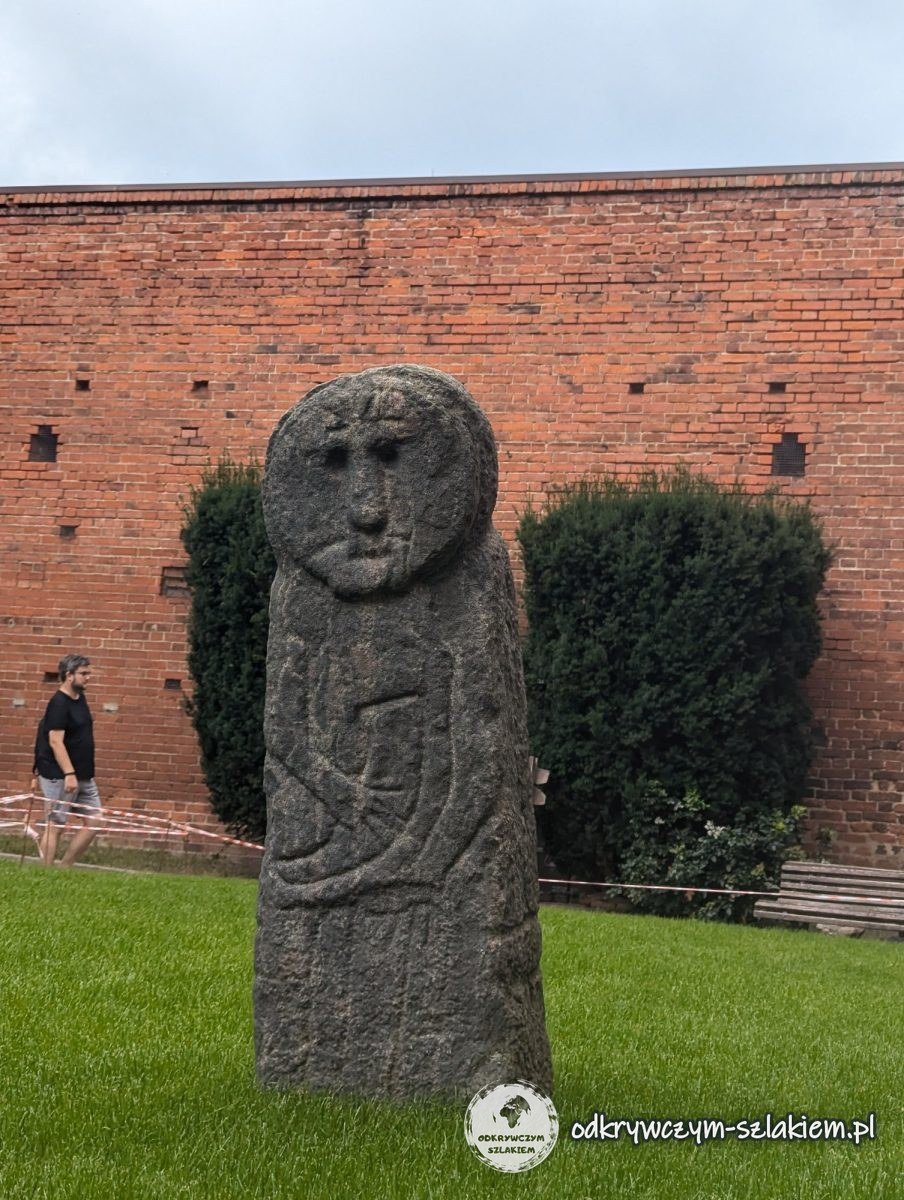 A Prussian stone figure (baba) on the lawn by the wall of the Castle of the Warmian Chapter